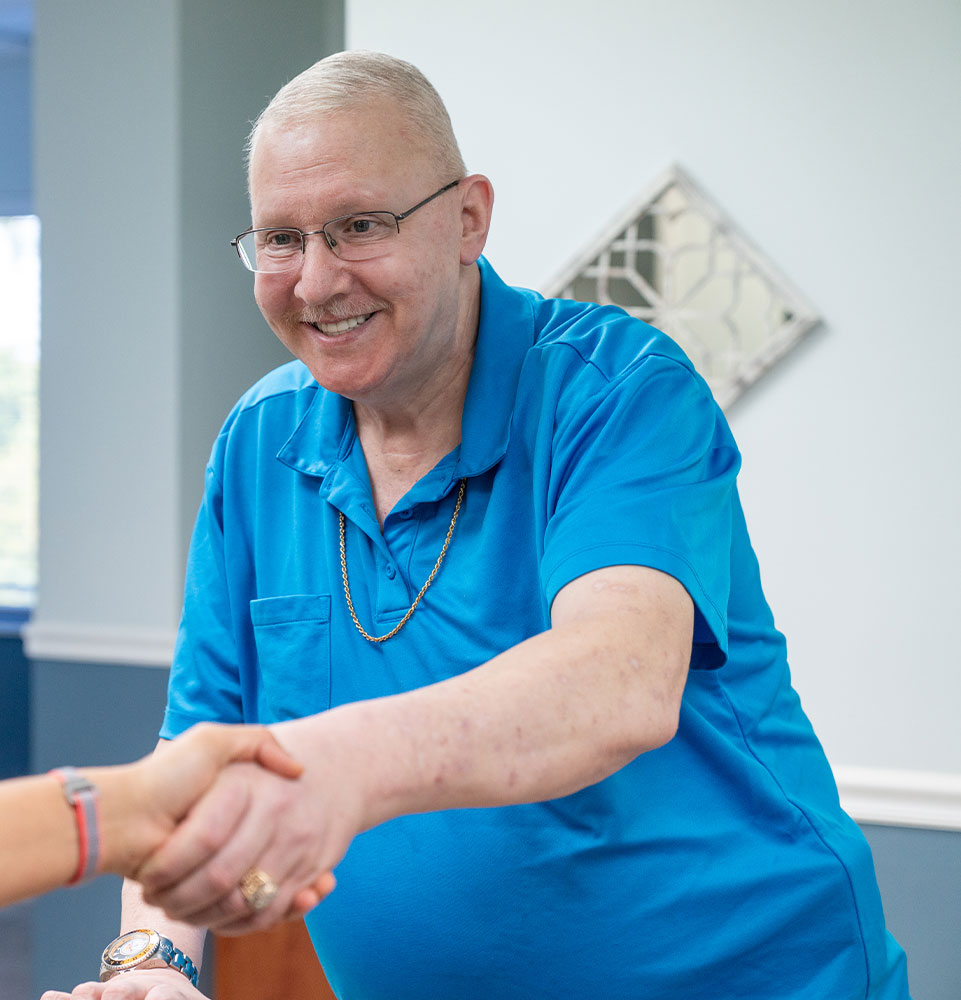 patient shaking hadns with staff member at the front desk of the dental center