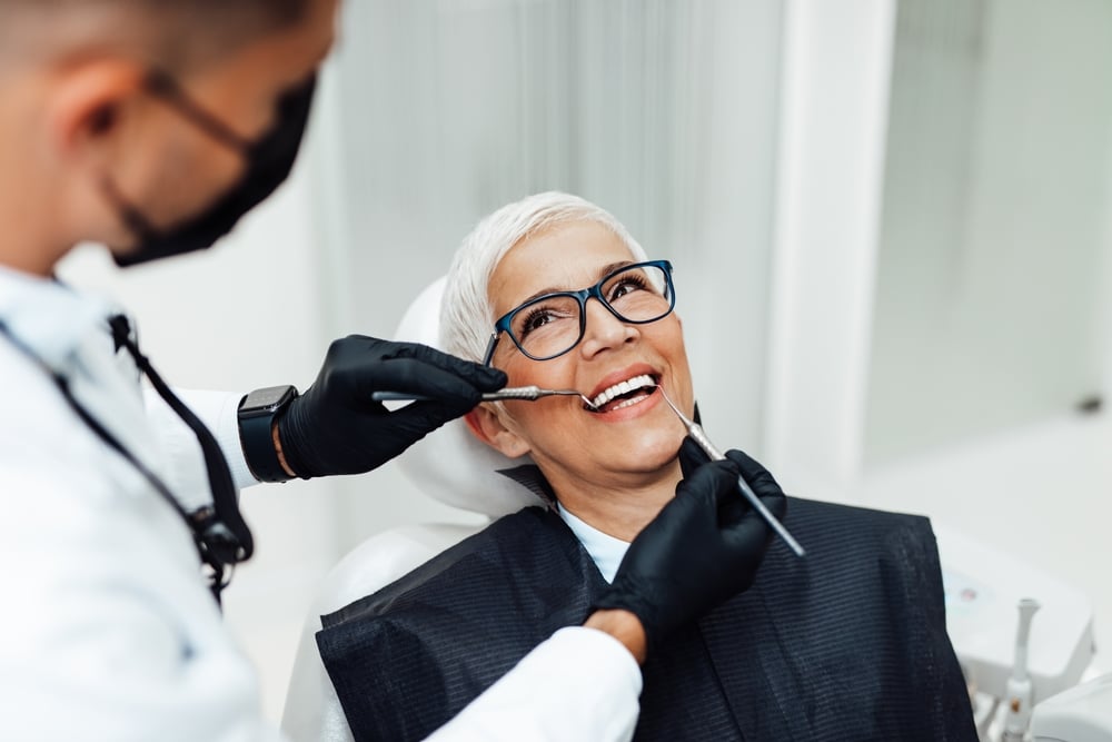 Dentist consulting with a patient about replacing missing teeth in a modern dental office.